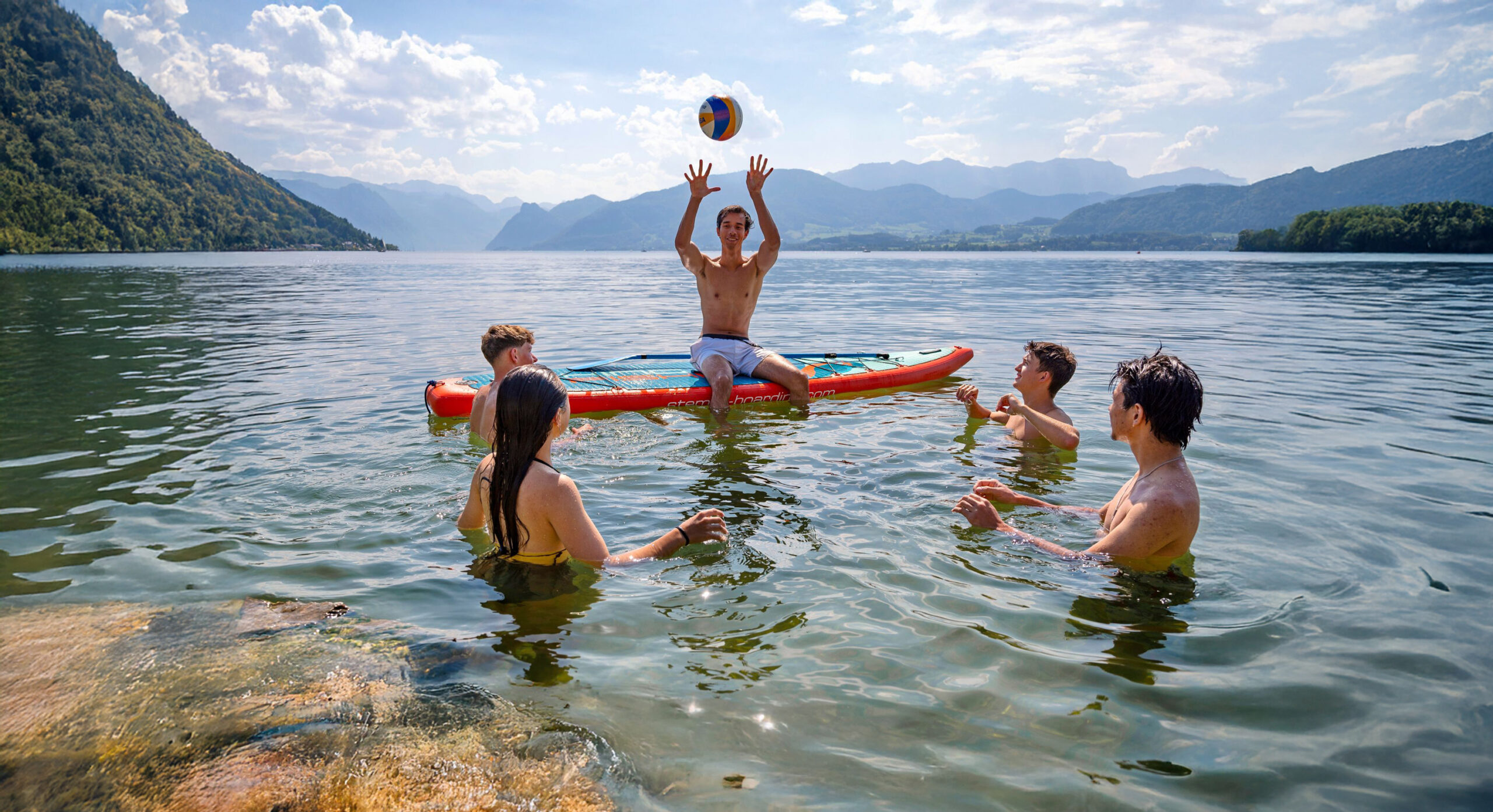 Freundesgruppe spielt Volleyball am See